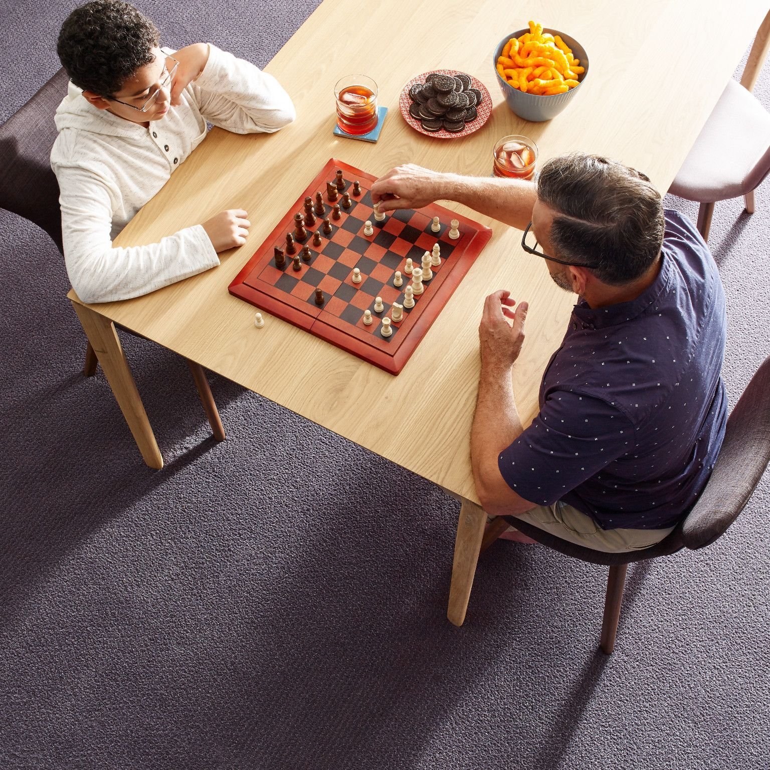 Father and son playing chess in a room with gray carpet floor from Direct Sales Floors in Danville, CA